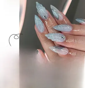 Detail view of almond nails with 3D shell texture, blue grey base and silver glitter
