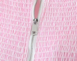 Macro shot of pink and white striped pleated fabric with a silver metal zipper detail