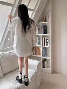 Detailed view of white ruffle socks with bow accents paired with black Mary Jane shoes