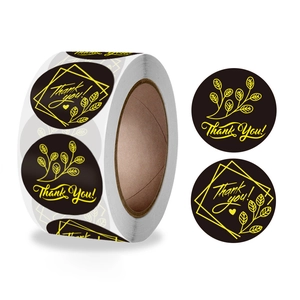 Close-up of black thank you roll stickers with elegant gold leaf and geometric patterns