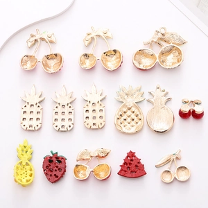 Detailed macro view of gold-plated fruit charms with crystals for DIY crafts and decor