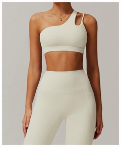 Detail shot of asymmetric hollow-out shoulder strap on a cream white yoga sports bra