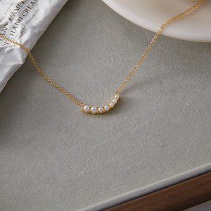 Detailed close-up of 18K gold stainless steel chain with elegant pearl smiley pendant