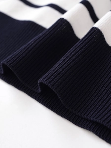 Close-up of contrast striped knit fabric and ribbed cuff texture on short sleeve top