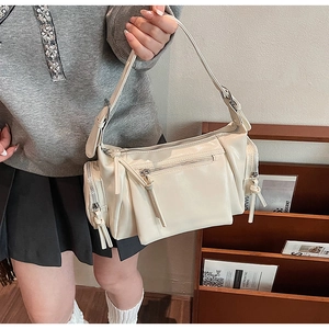 Détail du sac rétro blanc cassé avec fermetures éclair multiples et ferrures argentées