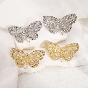 Detailed close-up of vintage butterfly earrings with elegant white pearl drops