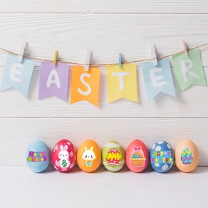 Easter decoration set featuring colorful eggs and an EASTER banner on white wood