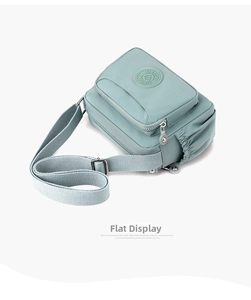 Detail view of mint green water-resistant nylon shoulder bag with multiple zip pockets