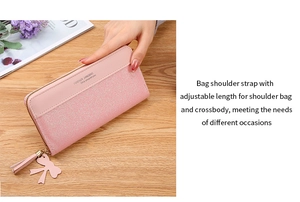 Pink glitter long wallet featuring a decorative tassel, bow, and adjustable shoulder strap