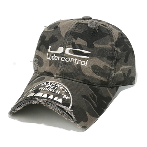 Detail of distressed camouflage baseball cap with embroidered lettering and worn brim