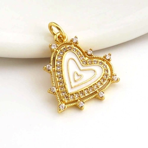 Macro detail of gold-plated heart pendant with white enamel and micro-set cubic zirconia