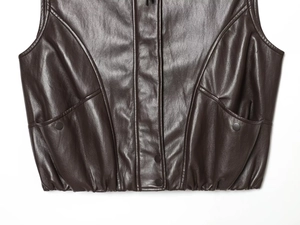 Detailed macro view of dark brown leather vest with snap buttons and elastic waist hem
