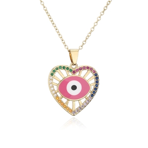 Close-up of heart-shaped evil eye pendant with rainbow zircons and 18K gold plating