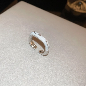 Detail view of the white enamel finish and rivet accents on the butterfly open ring