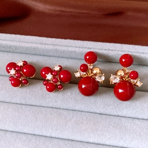 Detailed shot of vintage 18K gold-plated red bead drop earrings in a velvet box