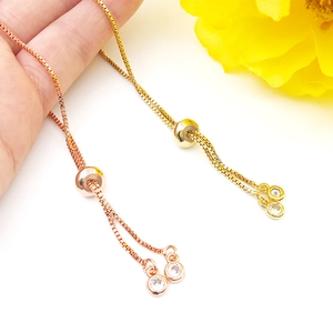 Detail of adjustable box chain bracelets in gold and rose gold with sliding closure