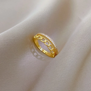 Detail of gold plated double-layer chain ring with micro-paved zircons on silk fabric