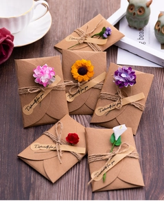 Dettaglio di buste in carta kraft con bouquet di fiori secchi e cordicelle di canapa