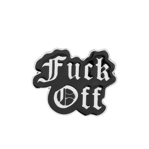 Detailed close-up of punk style Fuck Off enamel pin with black finish and gothic lettering