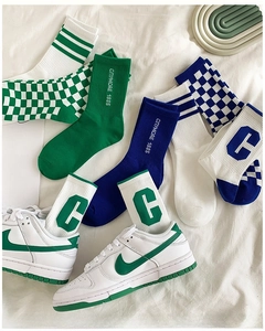 Flat lay of vintage checkered mid-tube athletic socks with retro letter jacquard and sneakers