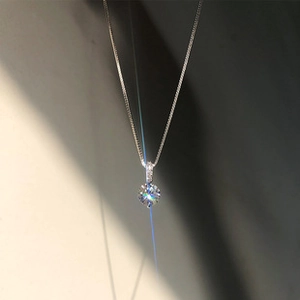Macro view of silver finish fine chain necklace with round brilliant cut solitaire pendant