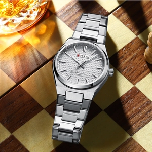 Silver stainless steel business watch displayed on a chess board with rich textures