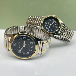Detail of silver and gold elastic steel strap watches with black dial and big numbers