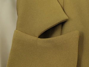 Detailed macro view of the khaki notched lapel and textured woven fabric on the blazer
