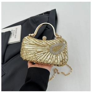 Macro view of gold sequin evening clutch featuring a rhinestone clasp and metallic handle