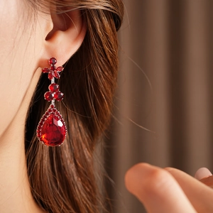 Macro shot of red zircon flower drop earrings with teardrop gemstones and micro-pave details