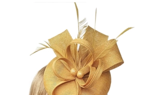 Detail of ginger fascinator hat with woven bow and delicate feathers on model