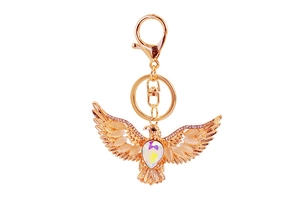 Macro detail of golden eagle keychain with rhinestones and iridescent gemstone