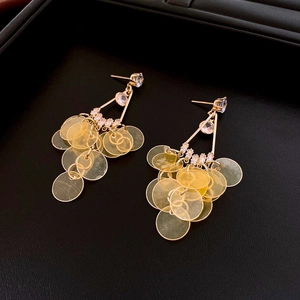 Detail of vintage gold earrings with rhinestones and layered yellow circular sequins