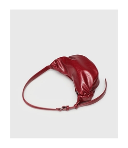 Detailed view of red pleated faux leather croissant bag with stylish long shoulder strap