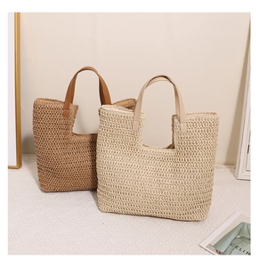 Detailed texture of hollowed-out straw tote bags with smooth leather handles