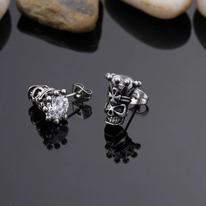 Macro shot of gothic silver skull stud earrings with large crown set clear zircon