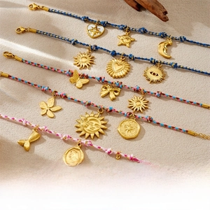 Détail de cordes bohèmes tissées main avec breloques dorées soleil, lune et mer