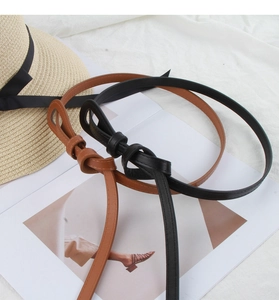 Detail of minimalist black and brown thin waist belts with a stylish knot design