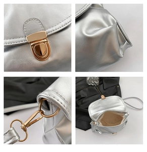 Detail of silver metallic handbag with gold snap buckle and premium leather texture
