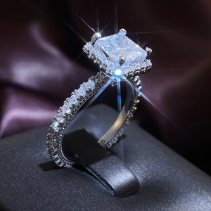 Macro view of square cut diamond ring featuring S925 hallmark and pave set band