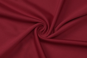 Close-up of deep red honeycomb knit fabric showing detailed texture and soft draping