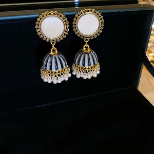 Detailed shot of ethnic phoenix crescent tassel earrings with blue enamel and pearls
