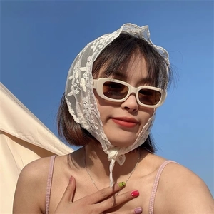 Close-up of white floral lace triangle kerchief with vintage cream rectangle sunglasses