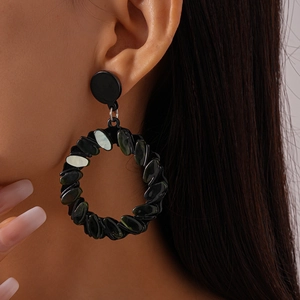 Close-up of geometric acrylic black hoop earrings on model featuring a multi-module design