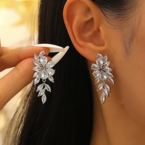 Close-up of sparkling pear-cut zircon drop earrings worn on ear with elegant details