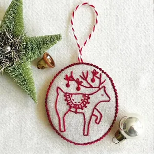 Jolly and Bright hand-embroidered Christmas ornament with red reindeer pattern