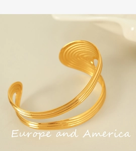 Close-up of 18K gold plated titanium cuff with luxury heavy wave texture and metallic finish