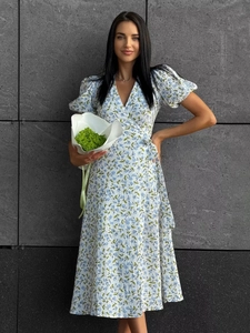 Detail of white cotton wrap dress with floral print featuring side waist ties and puff sleeves
