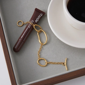 Detailed close-up of 18K gold stainless steel chain bracelet with modern OT toggle clasp