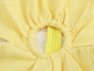 Dettaglio degli strati di tessuto giallo e della cerniera invisibile abbinata